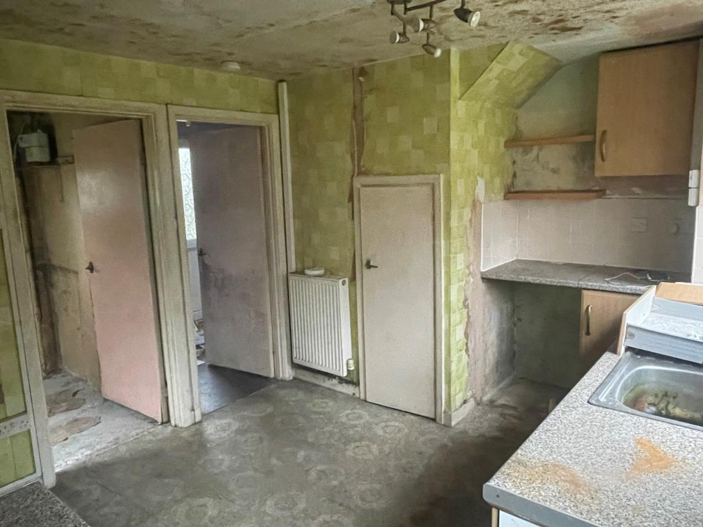 Lot: 135 - END-TERRACE HOUSE WITH GARAGE - Kitchen with units in poor condition